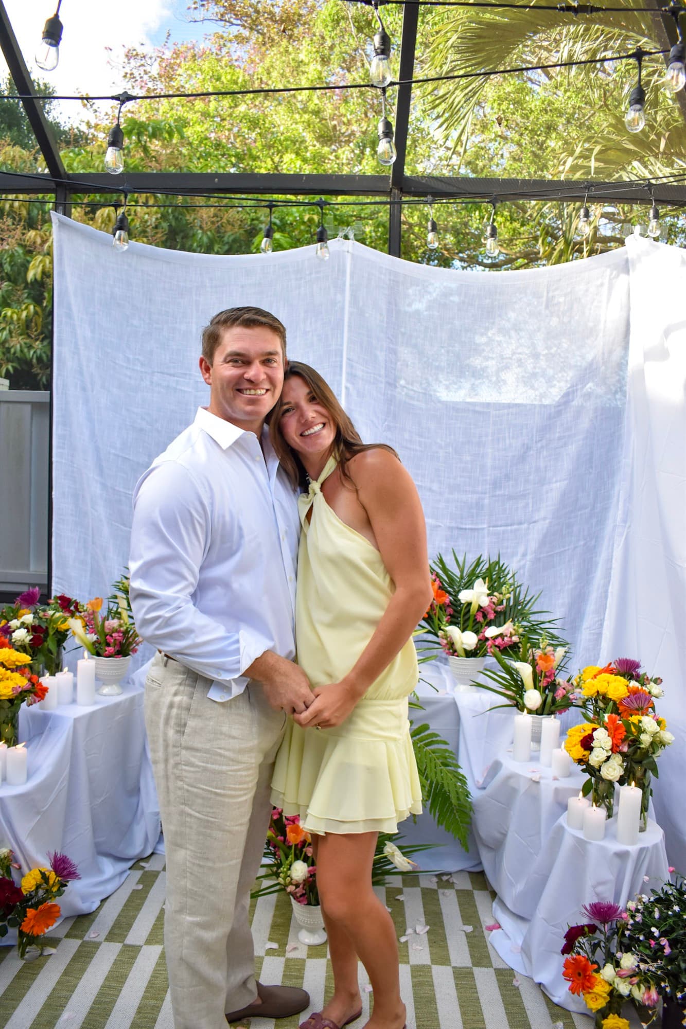 Morgan and Jon standing together in front of the white drapery, newly engaged.